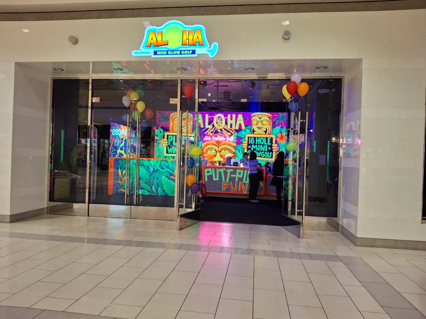 Aloha Mini Glow Golf mall storefront lit up with balloons